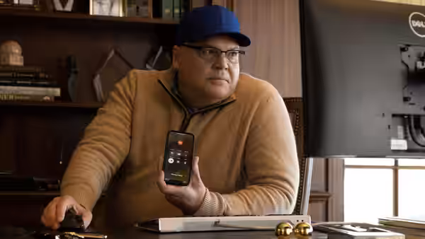 Gabe Plotkin (Seth Rogen) holding a phone showing a trading app