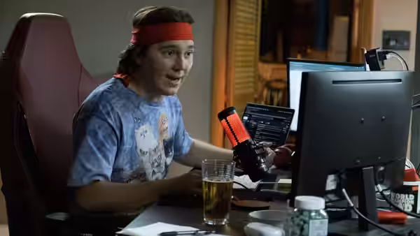 Keith Gill (Paul Dano) speaking into a microphone at his desk