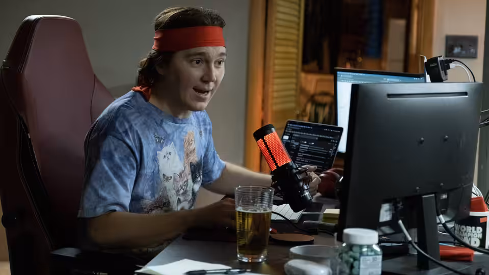 Keith Gill (Paul Dano) speaking into a microphone at his desk