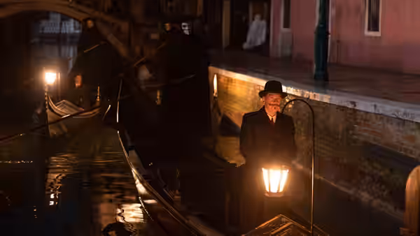 Hercule Poirot (Kenneth Branagh) in a gondola with masked figures