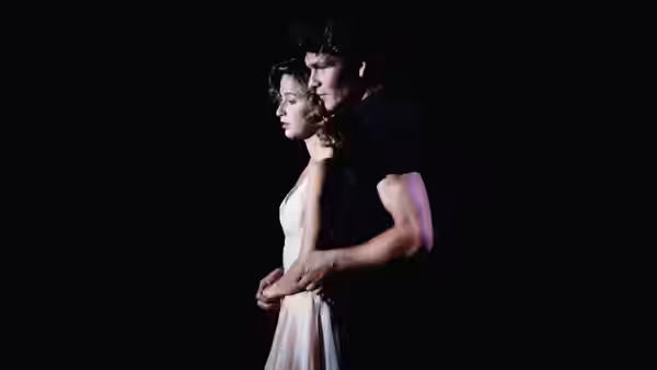 Johnny (Patrick Swayze) holding Baby (Jennifer Grey) from behind in darkness