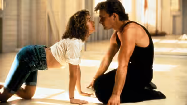 Baby (Jennifer Grey) on all fours facing Johnny (Patrick Swayze) indoors