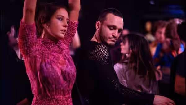 Adèle Exarchopoulos as Agathe dancing in a pink dress beside Franz Rogowski as Tomas