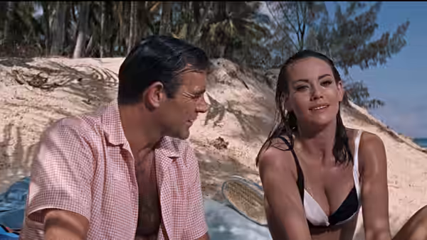 James Bond (Sean Connery) speaking with Domino (Claudine Auger) on a beach