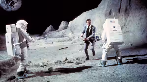 James Bond (Sean Connery) running between two astronauts on a rocky surface