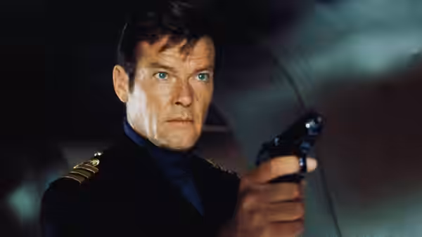James Bond (Roger Moore) aiming a pistol in naval uniform