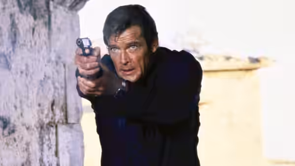 James Bond (Roger Moore) aiming a pistol near a weathered stone wall
