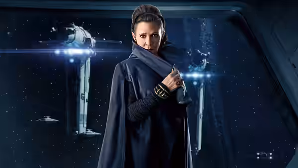 Leia Organa (Carrie Fisher) stands in a starship corridor holding her cloak