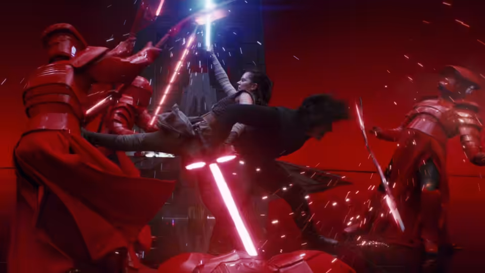 Rey (Daisy Ridley) leaps over Kylo Ren (Adam Driver) fighting red-armored guards with lightsabers