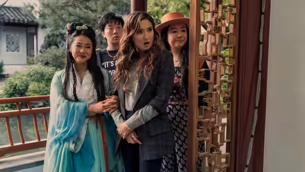 Women clustered at an ornate doorway with one in blue robe