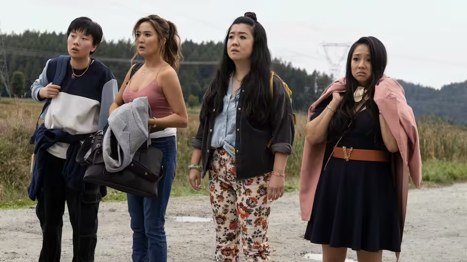 Four women standing together on a rural dirt road looking ahead