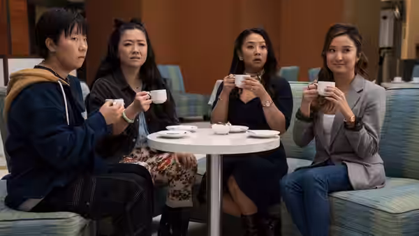 Four women holding teacups while seated around a small table