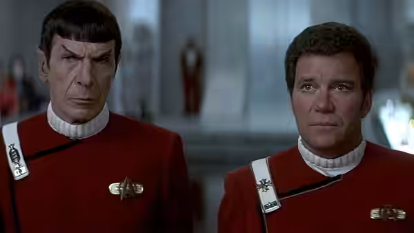 Spock (Leonard Nimoy) stands beside a fellow officer in red Starfleet uniforms