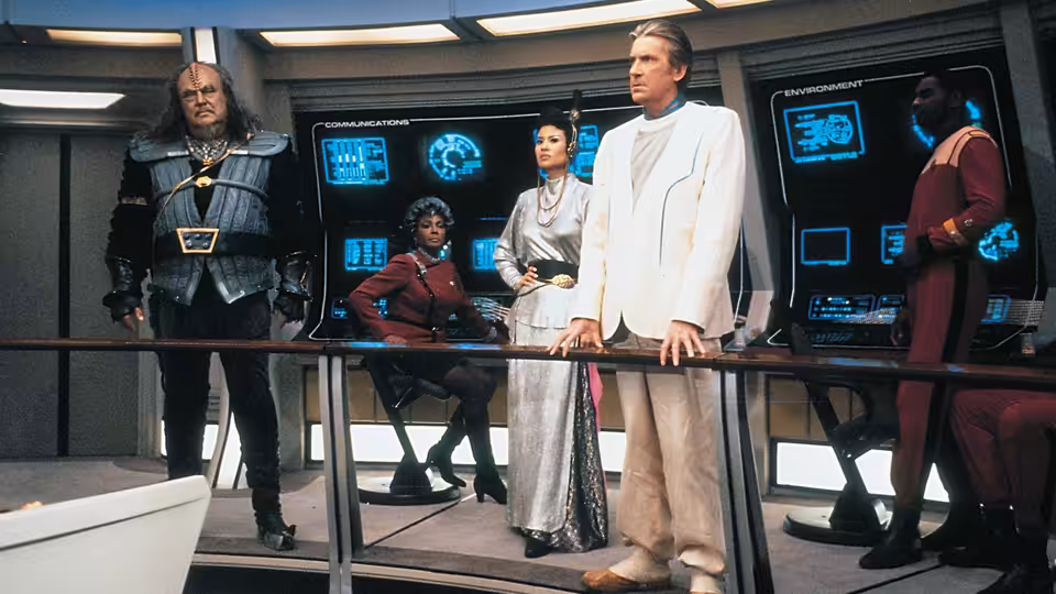 Uhura (Nichelle Nichols) among officers and aliens in a starship control room