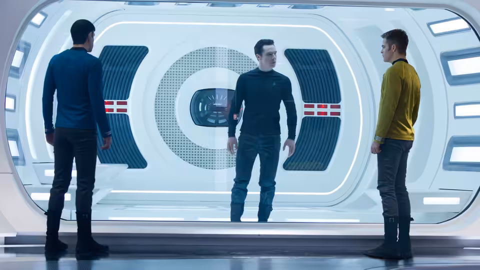 Spock (Zachary Quinto) stands with two officers in a white corridor