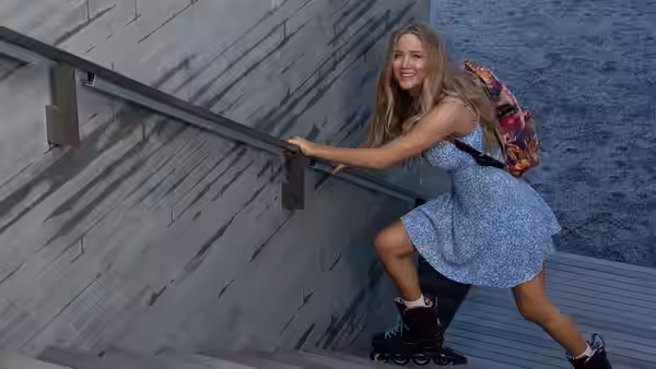 Maddie Barker (Jennifer Lawrence) climbing stairs on rollerblades beside the water