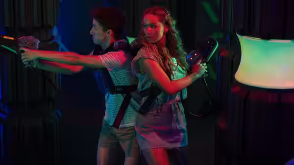 Maddie Barker (Jennifer Lawrence) and Percy Becker (Andrew Barth Feldman) aiming guns back to back