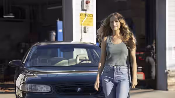 Maddie Barker (Jennifer Lawrence) walking past a car in an auto repair shop