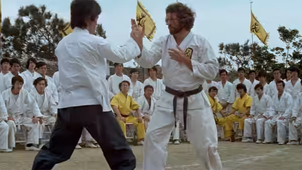 Roper (John Saxon) faces Lee (Bruce Lee) as students watch their martial arts match