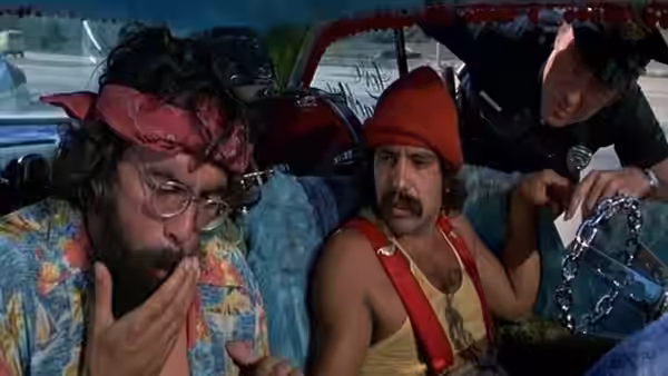 Pedro (Cheech Marin) puffs smoke beside Man (Tommy Chong) as a police officer leans into their car