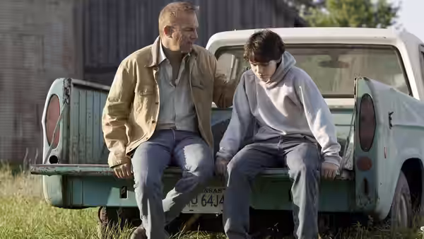 Jonathan Kent sits beside young Clark on the tailgate of a pickup