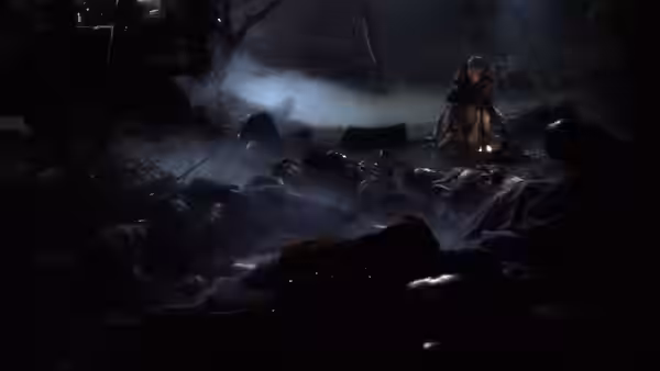 A cloaked figure walks among fallen soldiers beside a small fire at night