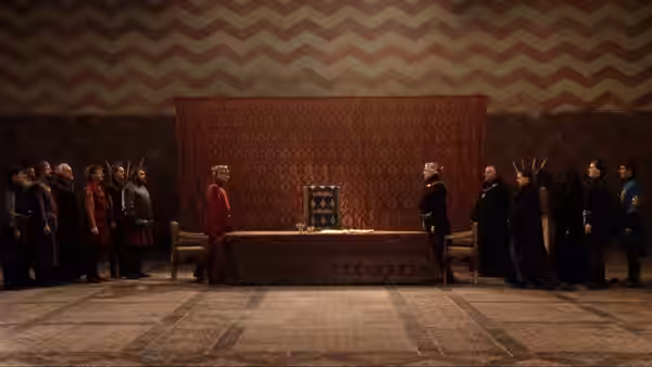 Two opposing groups face each other across a table in a richly furnished hall