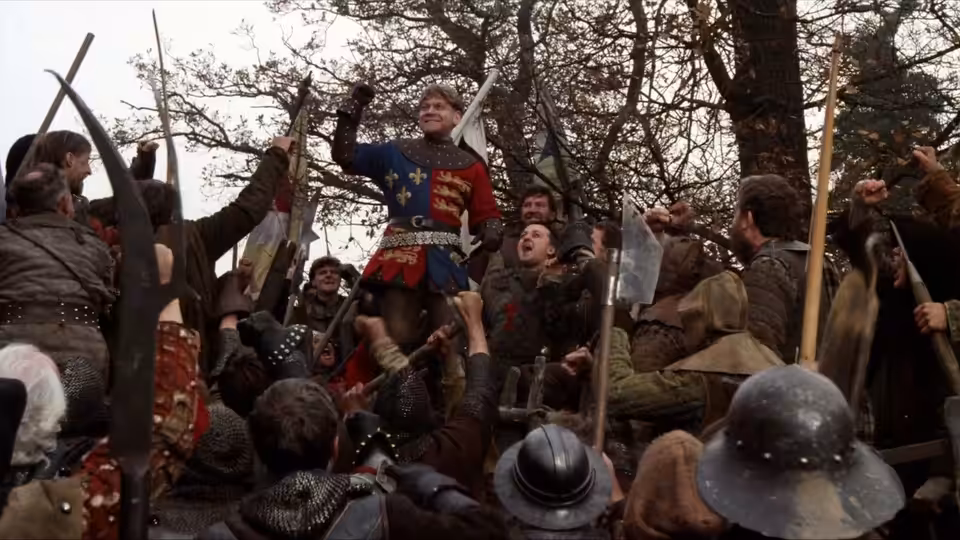 Henry V (Kenneth Branagh) raises his sword above cheering soldiers on the battlefield