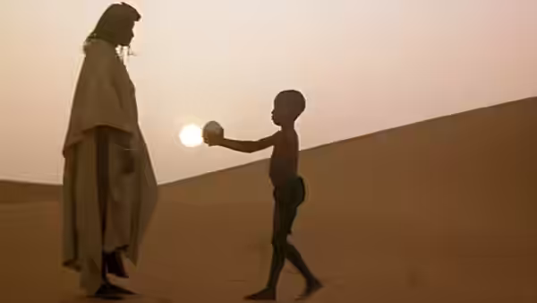 A cloaked adult faces a child holding the setting sun over the desert