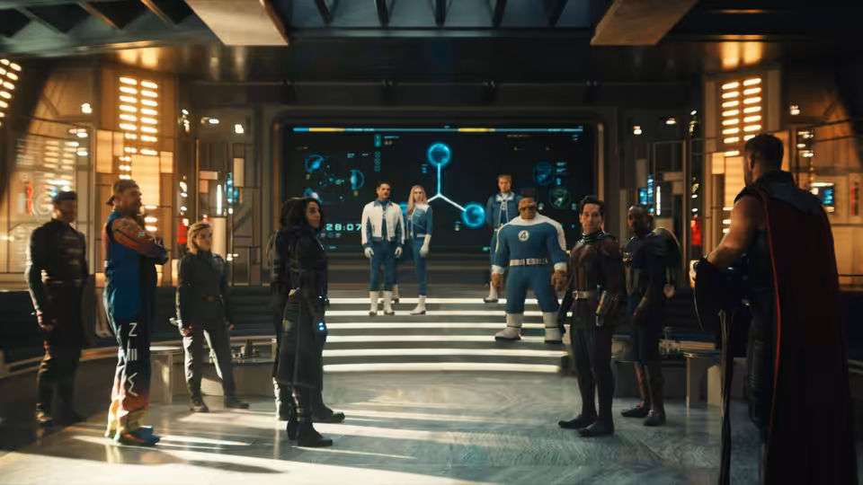 A group of heroes gathers around a holographic display in a high-tech headquarters
