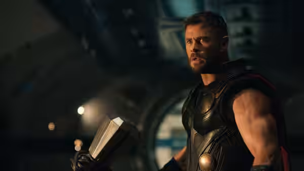 Thor (Chris Hemsworth) grips his hammer aboard a dimly lit spacecraft