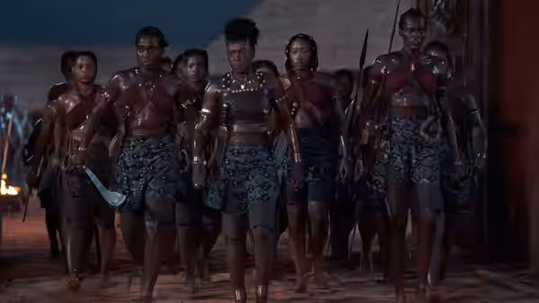 Nanisca (Viola Davis) leads armed Agojie warriors through a palace courtyard