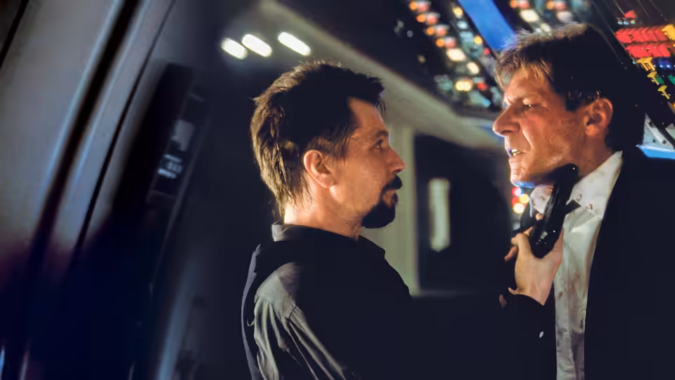 Ivan Korshunov (Gary Oldman) grips James Marshall (Harrison Ford) by the collar in the aircraft cockpit
