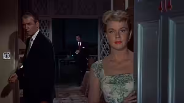 Jo McKenna (Doris Day) stands in a doorway as Ben McKenna (James Stewart) turns toward her