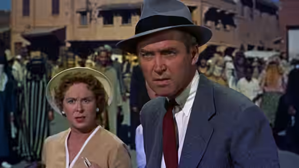 Ben McKenna (James Stewart) and Jo McKenna (Doris Day) stand among a crowd in a street