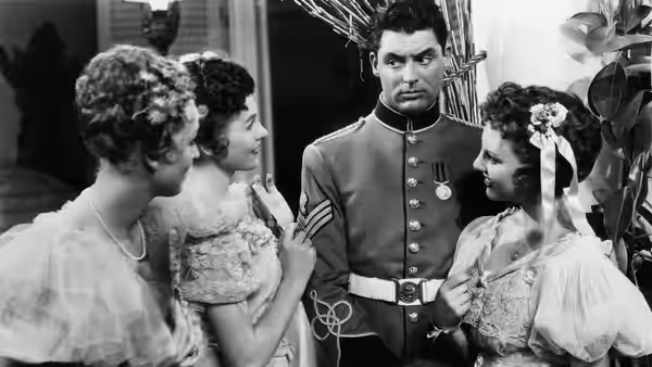 A uniformed officer stands among women gathered around him indoors