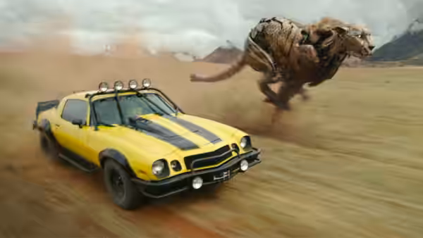 Yellow muscle car speeding across desert sand with robotic beast leaping behind