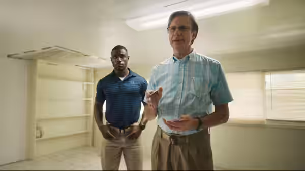 Agent Taylor (Marchánt Davis) and Agent Garrick (Josh Hamilton) in an unfurnished room