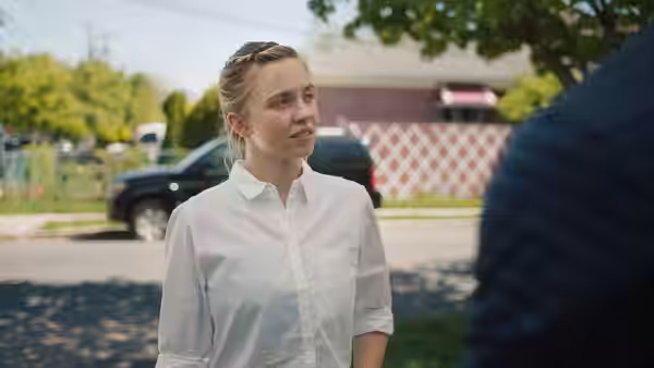 Reality Winner (Sydney Sweeney) speaking to a man outdoors on a street