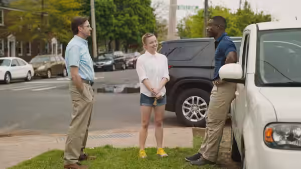 Reality Winner (Sydney Sweeney) speaking with two FBI agents on a suburban street