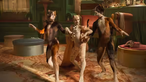 Victoria dances between two other cats in a green Victorian room