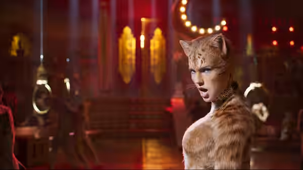 Bombalurina looks back over her shoulder in a red theater