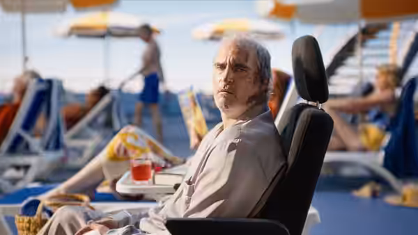 Beau Wassermann (Joaquin Phoenix) seated on a lounge chair by a pool