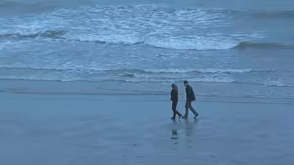 Danny Flynn and Maggie Hamill walk together along the shoreline
