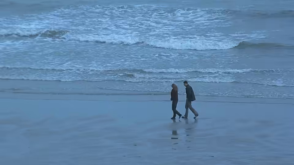 Danny Flynn and Maggie Hamill walk together along the shoreline