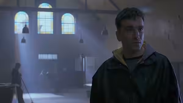 Danny Flynn stands in a boxing gym as people train behind him