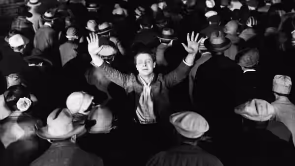 John 'Johnny' Sims (James Murray) raises his hands above a crowd