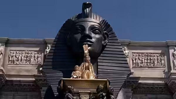 Large sphinx monument with a small golden litter on a platform in front