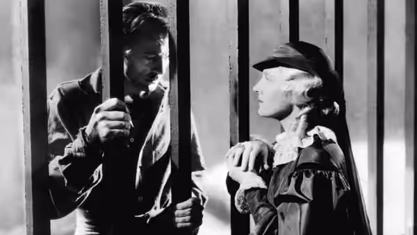 Peter Ibbetson (Gary Cooper) and Mary, Duchess of Towers (Ann Harding) face each other through prison bars