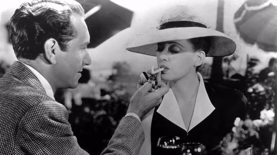 Jerry (Paul Henreid) lights Charlotte’s (Bette Davis) cigarette aboard a ship